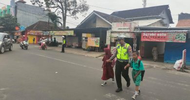 Wujud Kepedulian, Anggota Sat Lantas Polres Metro Bantu Anak Sekolah Menyebrangkan Jalan